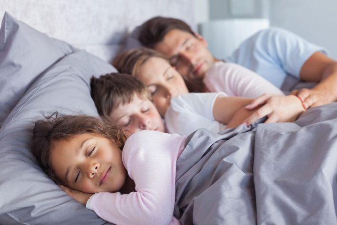 family-sleeping-together-in-bed-8d535b12ae624ef9b01d2259c41504ec